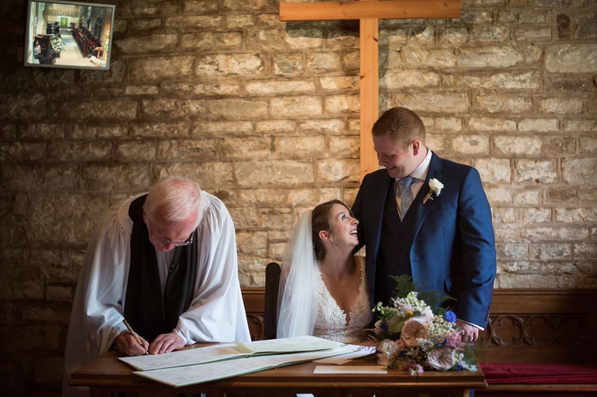 Signing wedding register at Canford magna church wedding