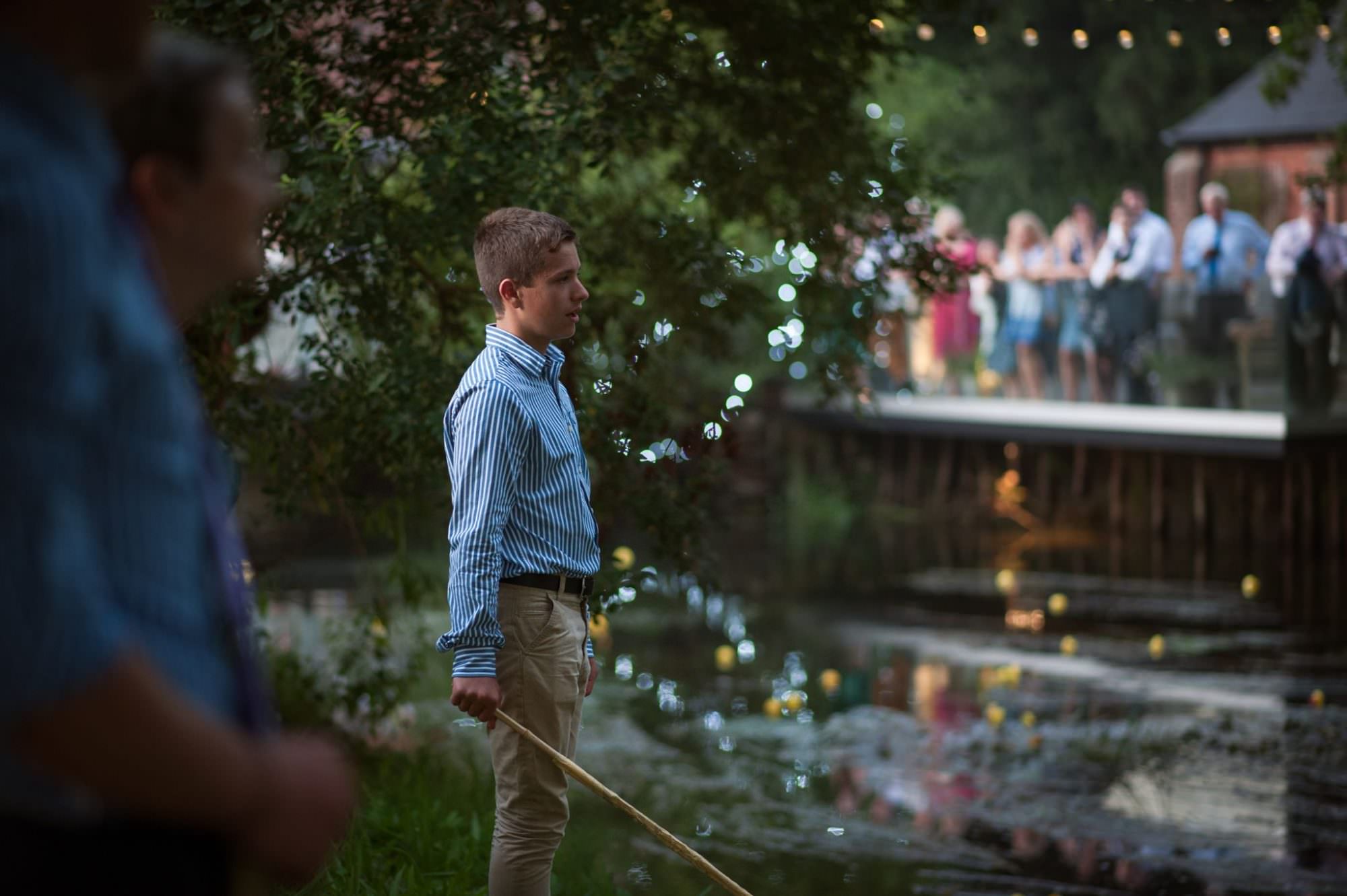Guest waiting for the duck race at Sopley Mill wedding